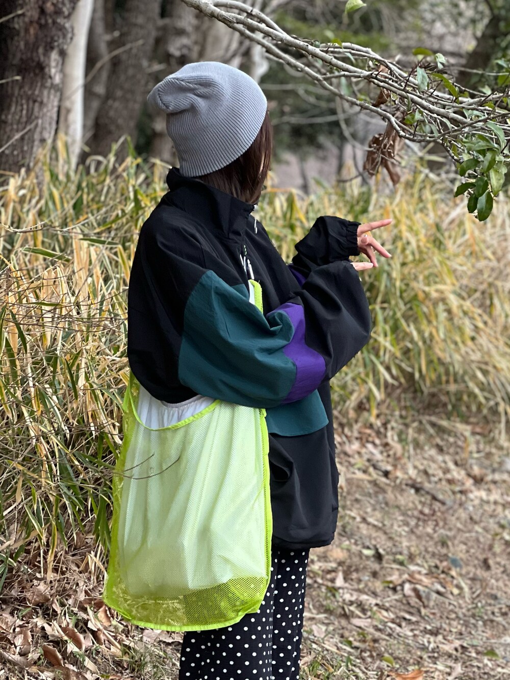 ブラック系のナイロンジャケット、ブラック系のその他パンツ、ブラック系のスニーカーを着用したレディースの春コーディネートの2枚目の写真