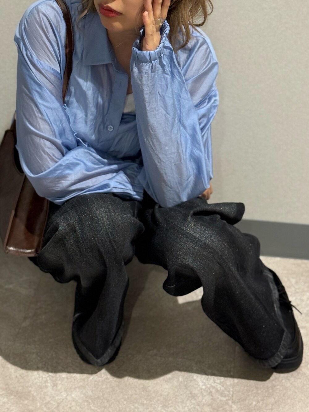 ブルー系のシャツ/ブラウス、ブラウン系のショルダーバッグ、ブラック系のデニムパンツを着用したレディースの秋コーディネートの3枚目の写真