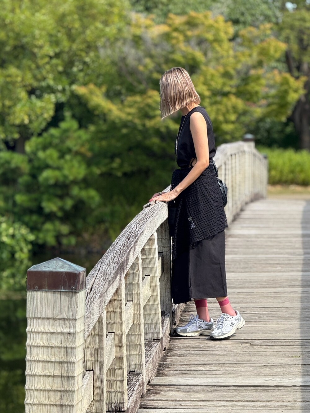 ブラック系のトートバッグ、シルバー系のスニーカー、ブラック系のワンピースを着用したレディースの秋コーディネートの3枚目の写真