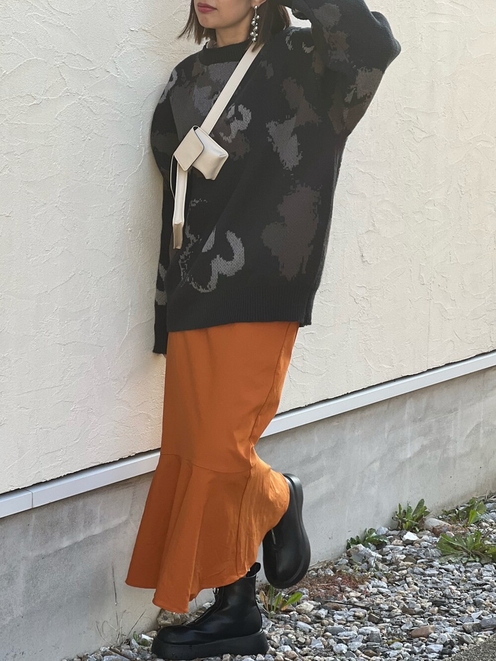 ブラック系のニット/セーター、イエロー系のスカート、ブラック系のブーツを着用したレディースの秋コーディネートの4枚目の写真