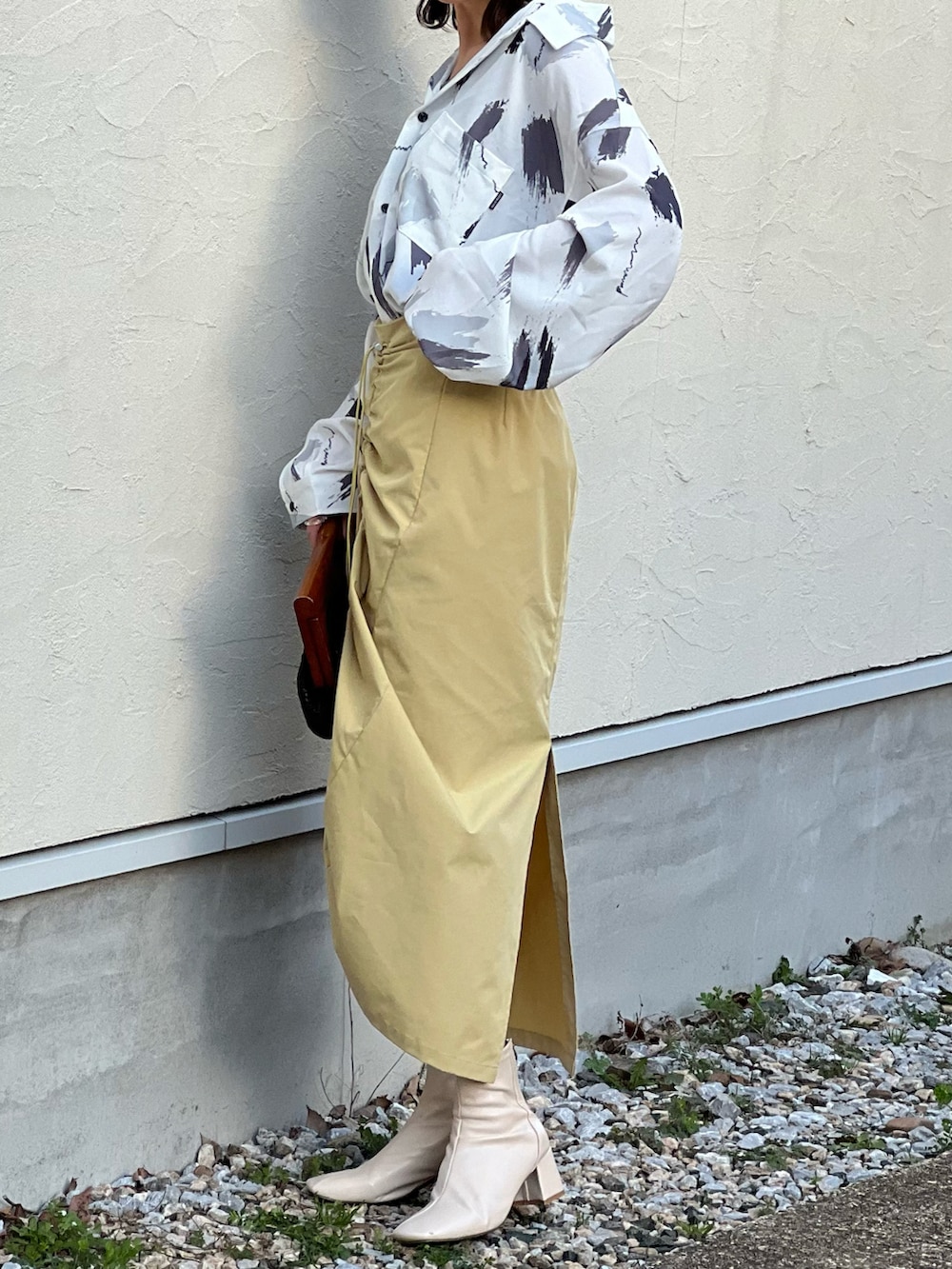 ホワイト系のシャツ/ブラウス、イエロー系のスカート、ホワイト系のブーツを着用したレディースの冬コーディネートの3枚目の写真