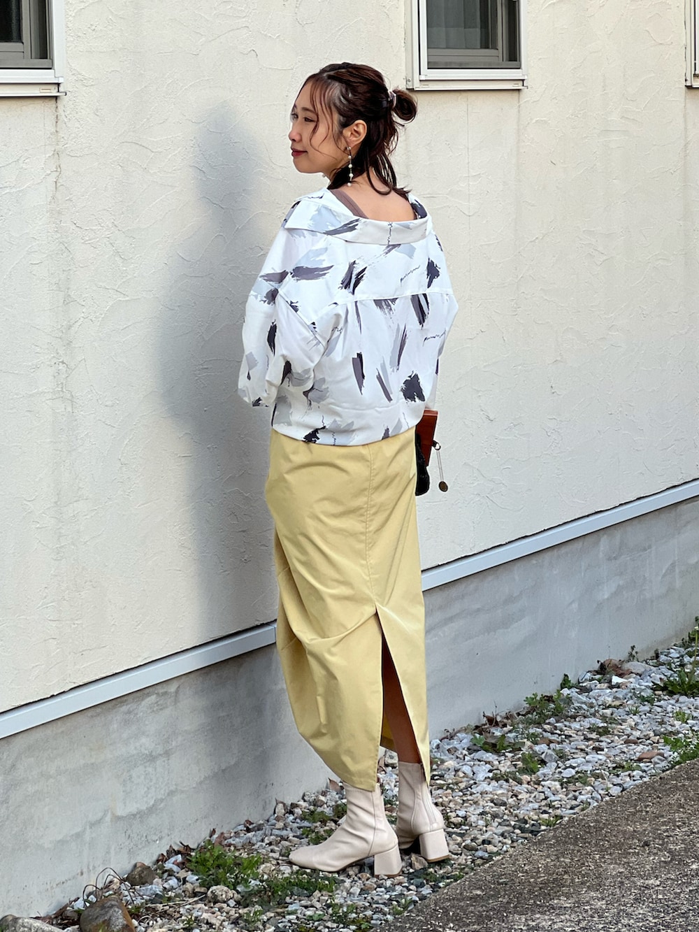 ホワイト系のシャツ/ブラウス、イエロー系のスカート、ホワイト系のブーツを着用したレディースの冬コーディネートの5枚目の写真