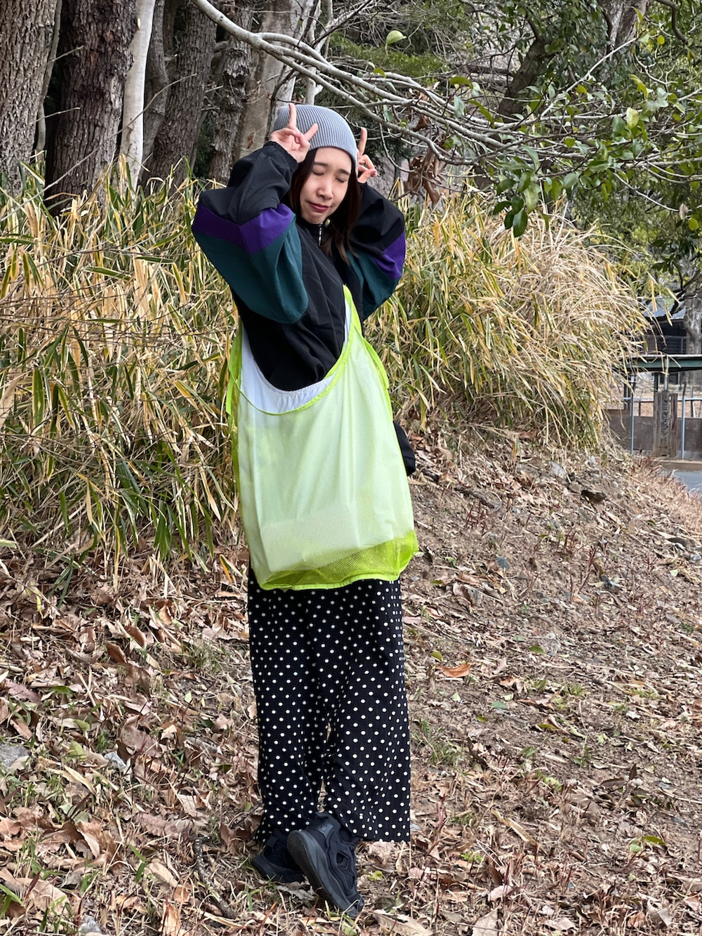 ブラック系のナイロンジャケット、ブラック系のその他パンツ、ブラック系のスニーカーを着用したレディースの春コーディネートの3枚目の写真