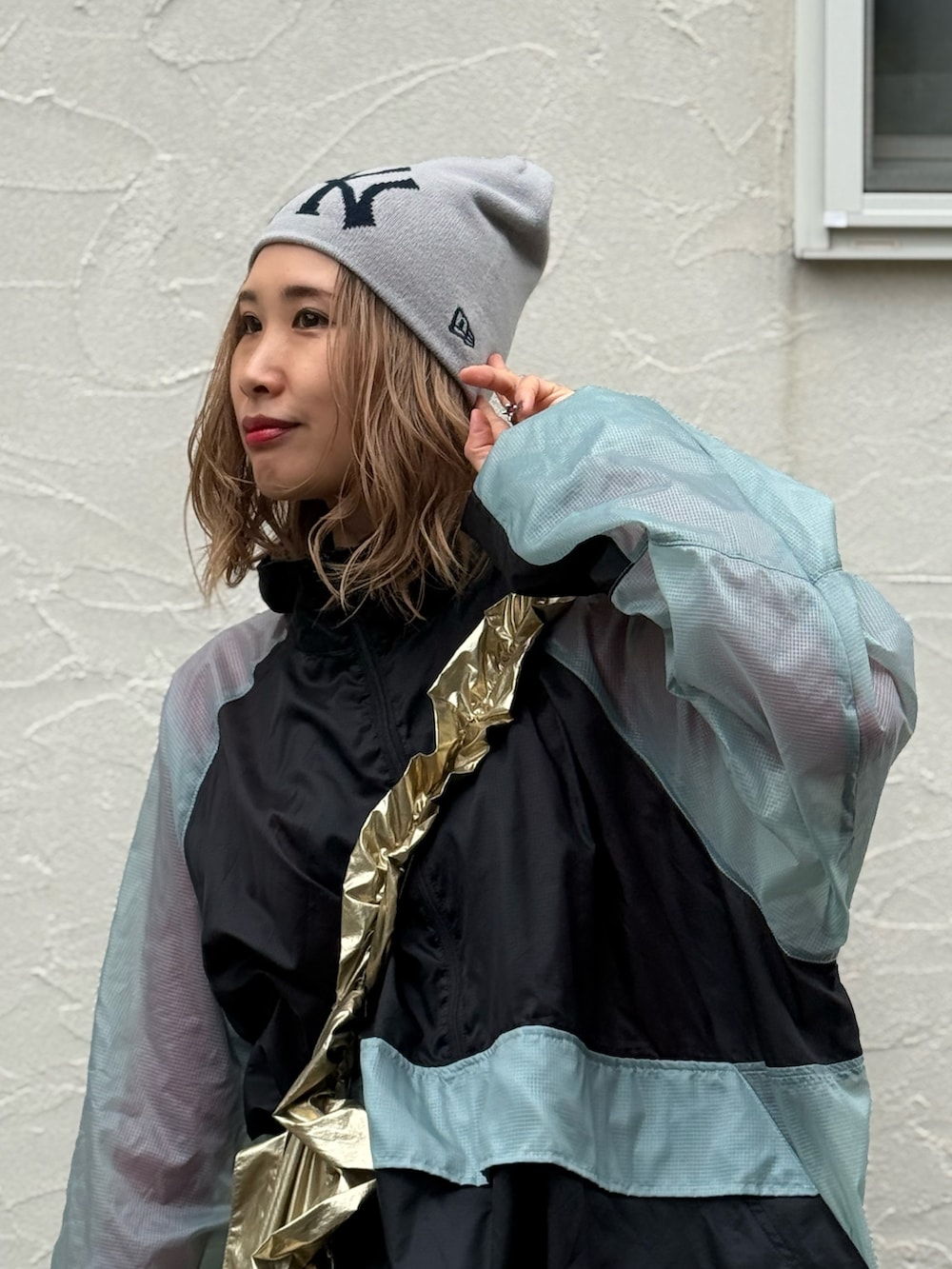 グレー系のその他パンツ、シルバー系のスニーカー、ブラック系のナイロンジャケットを着用したレディースの秋コーディネートの2枚目の写真