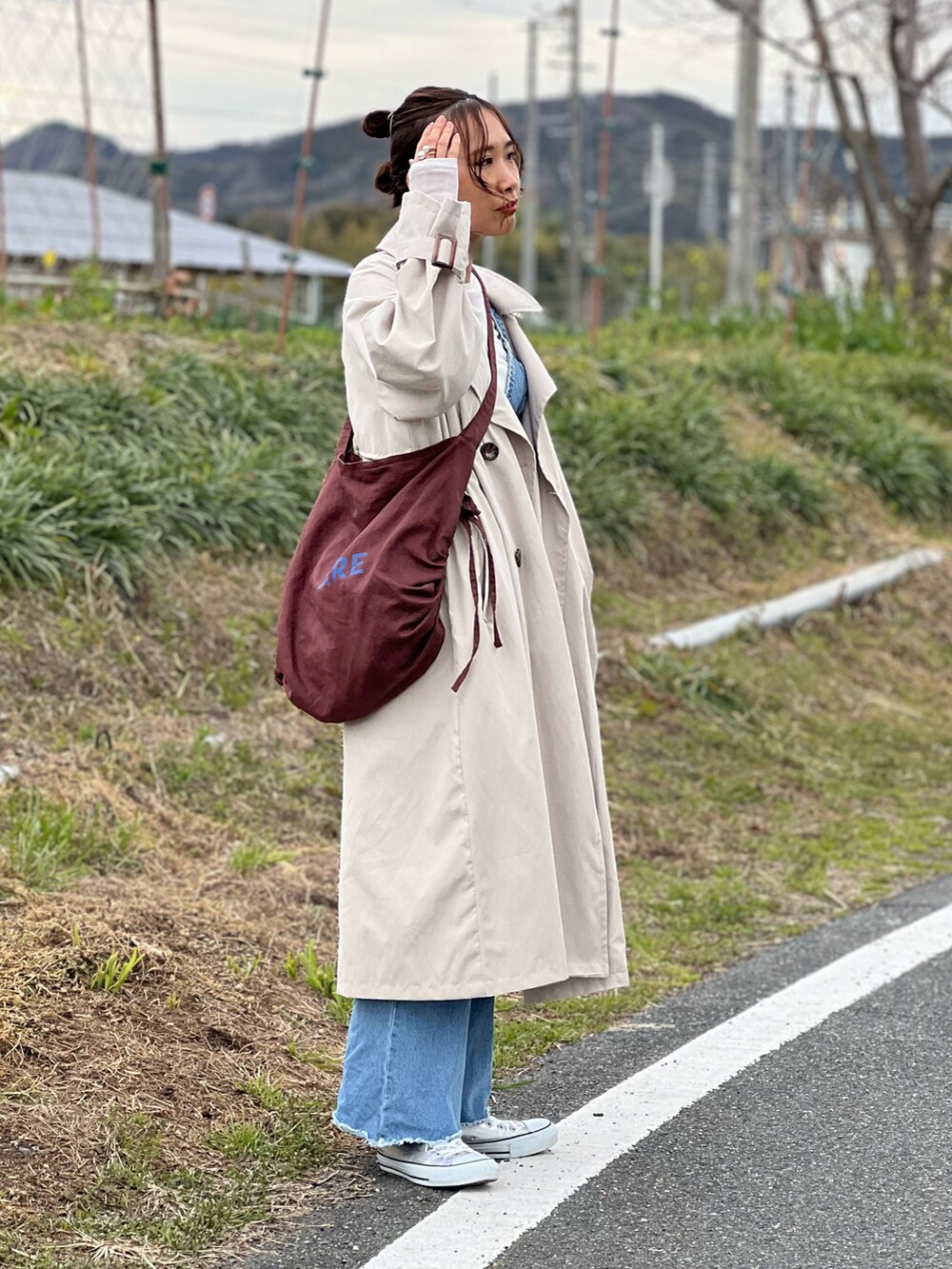 ベージュ系のトレンチコート、ホワイト系のTシャツ/カットソー、ブルー系のその他トップスを着用したレディースの春コーディネートの2枚目の写真