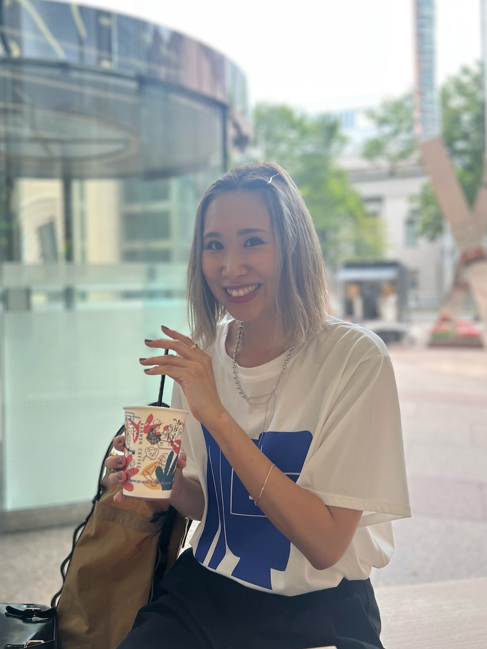 ホワイト系のTシャツ/カットソー、ベージュ系のトートバッグ、ブラック系のパンツを着用したレディースの秋コーディネートの4枚目の写真