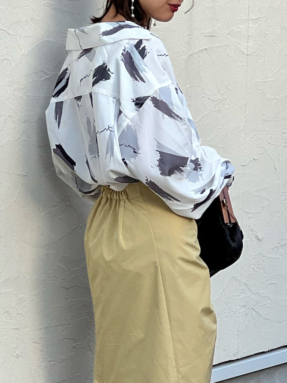 ホワイト系のシャツ/ブラウス、イエロー系のスカート、ホワイト系のブーツを着用したレディースの冬コーディネートの2枚目の写真