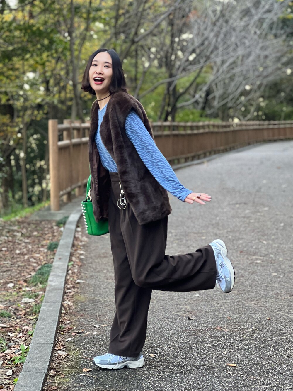 ブラウン系のベスト、ブラウン系のパンツ、シルバー系のスニーカーを着用したレディースの秋コーディネートの2枚目の写真