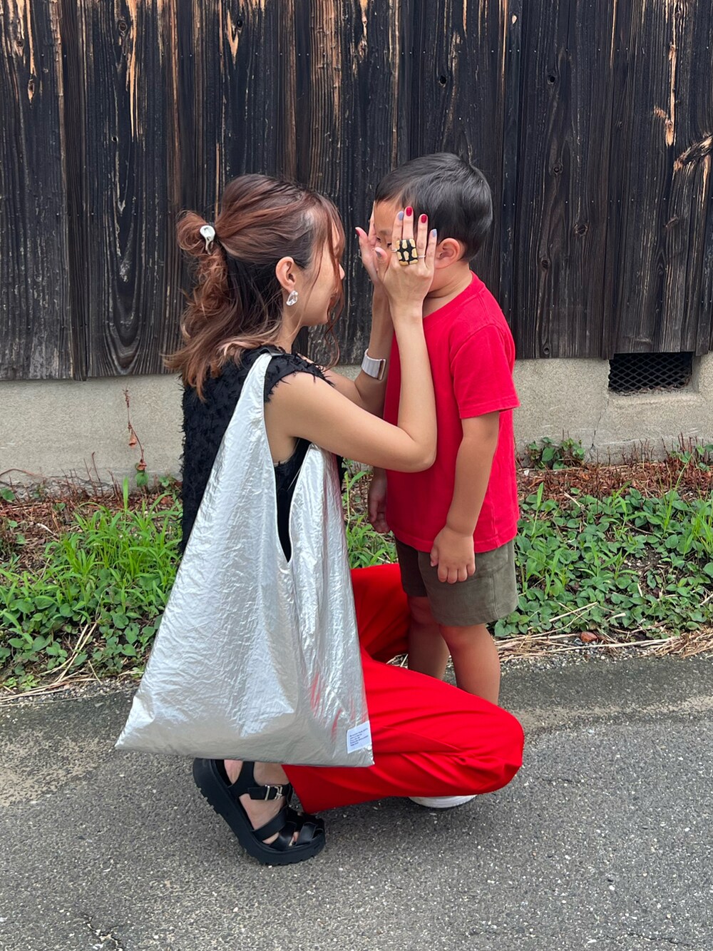 ブラック系のシャツ/ブラウス、レッド系のスラックス、ブラック系のサンダルを着用したレディースの夏コーディネートの3枚目の写真