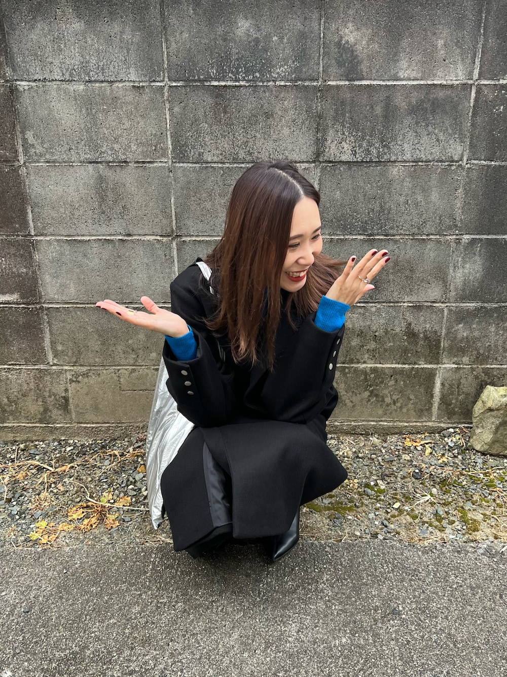 ブラック系のチェスターコート、ブルー系のニット/セーター、ブラック系のその他パンツを着用したレディースの秋コーディネートの5枚目の写真