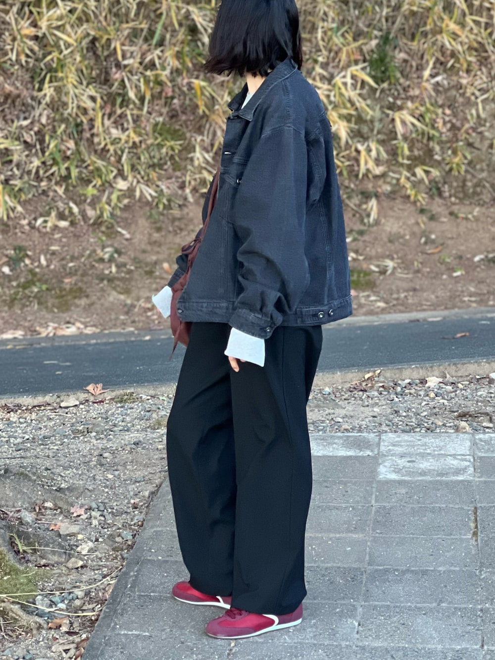 ブラック系のデニムジャケット、グレー系のスウェット、ブラック系のパンツを着用したレディースの冬コーディネートの3枚目の写真