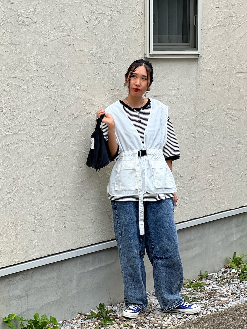 ブラック系のTシャツ/カットソー、ホワイト系のベスト、ブルー系のデニムパンツを着用したレディースの夏コーディネートの5枚目の写真