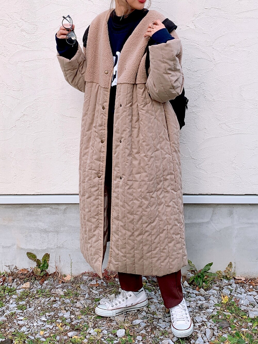 ベージュ系のノーカラーコート、ブラウン系のその他パンツ、ホワイト系のスニーカーを着用したレディースの冬コーディネートの3枚目の写真