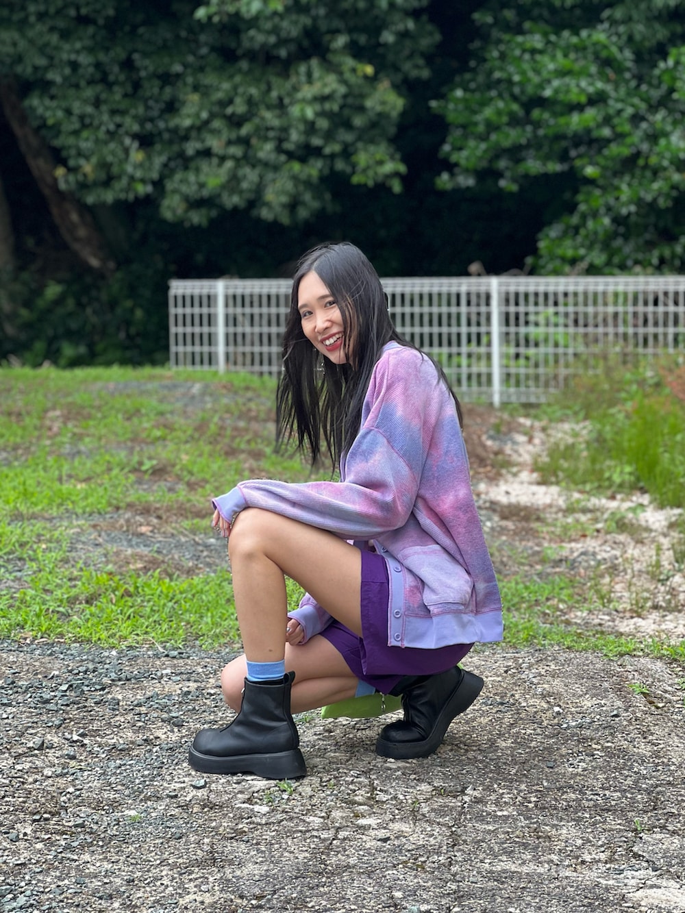 パープル系のパンツ、パープル系のカーディガン/ボレロ、ブラック系のブーツを着用したレディースの春コーディネートの2枚目の写真