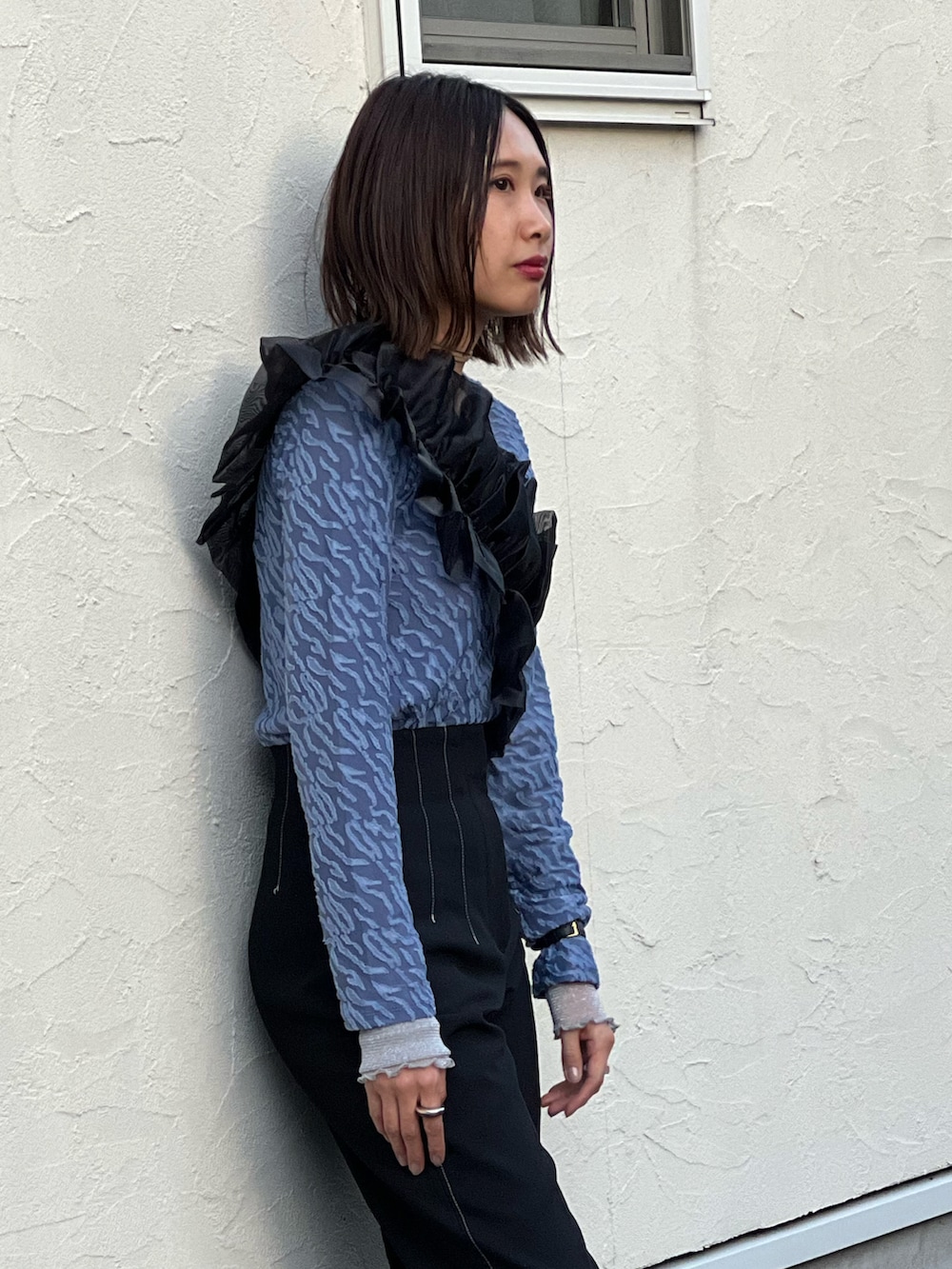 ブラック系のパンツ、ブラック系のブーツ、ブラック系のベルトを着用したレディースの秋コーディネートの2枚目の写真