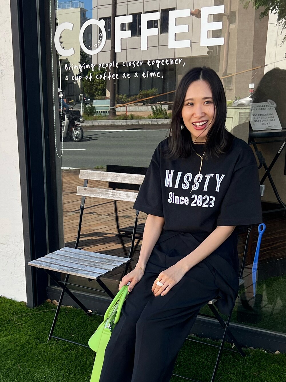 ブラック系のTシャツ/カットソー、ブラック系のブーツ、グリーン系のボストンバッグを着用したレディースの春コーディネートの5枚目の写真