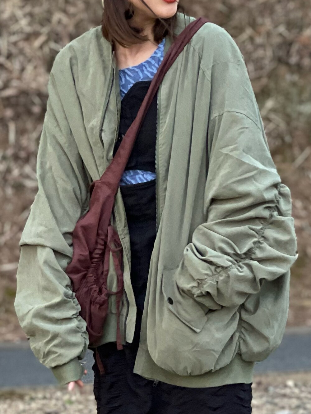 グリーン系のMA-1、ブラック系のキャミソール、ブラック系のスカートを着用したレディースの春コーディネートの3枚目の写真