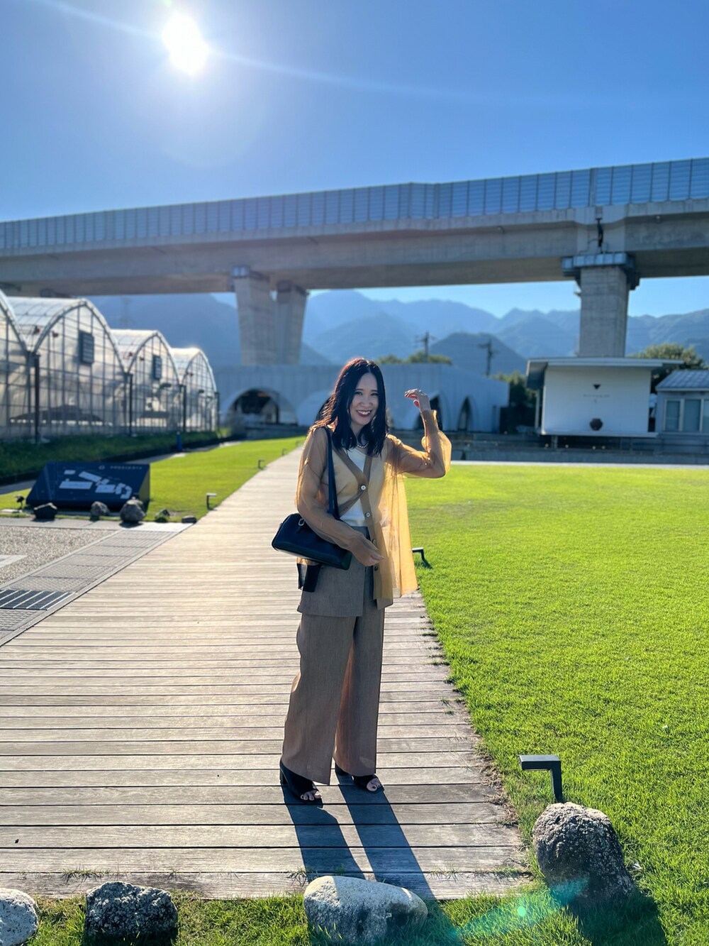 イエロー系のカーディガン/ボレロ、ベージュ系のその他パンツ、ブラック系のブーツを着用したレディースの夏コーディネートの4枚目の写真