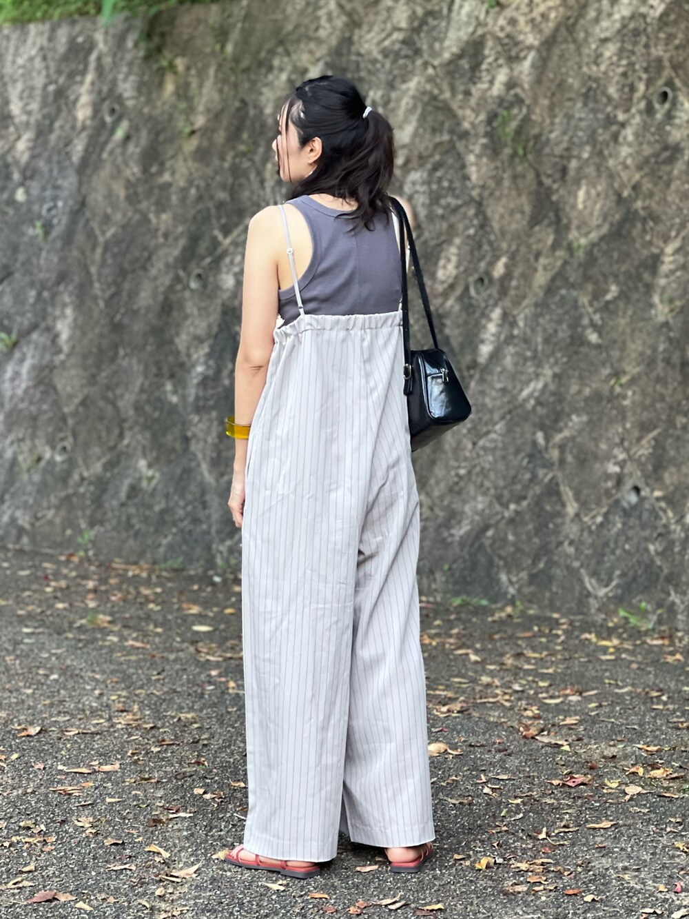 ベージュ系のサロペット/オーバーオール、ブラック系のボストンバッグ、オレンジ系のサンダルを着用したレディースの夏コーディネートの5枚目の写真