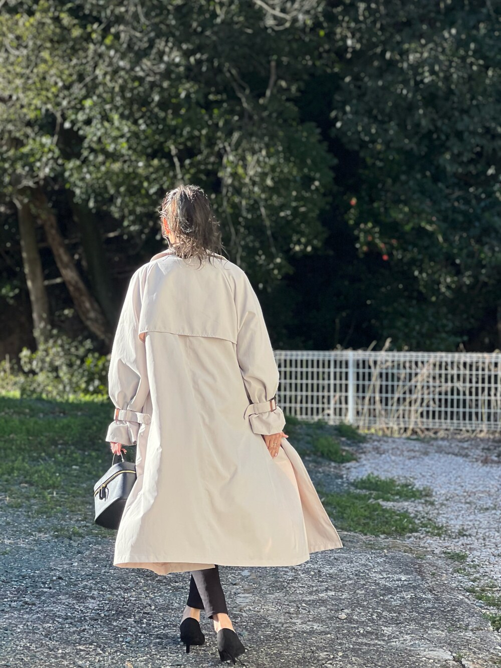 ベージュ系のトレンチコート、ブルー系のシャツ/ブラウス、ブラック系のその他パンツを着用したレディースの春コーディネートの4枚目の写真