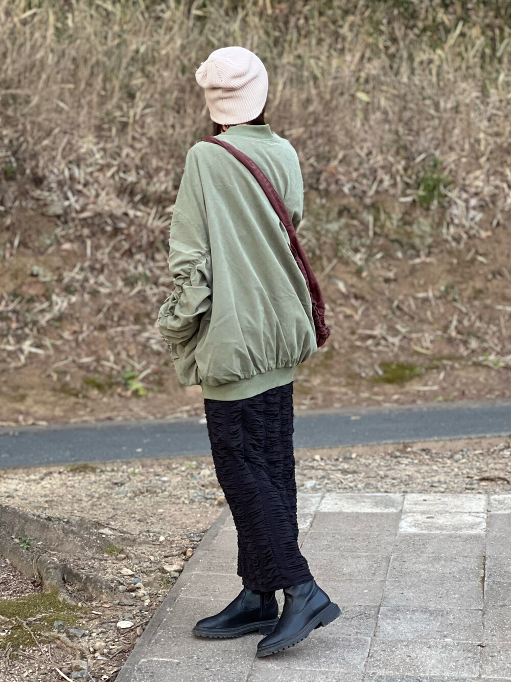 グリーン系のMA-1、ブラック系のキャミソール、ブラック系のスカートを着用したレディースの春コーディネートの4枚目の写真