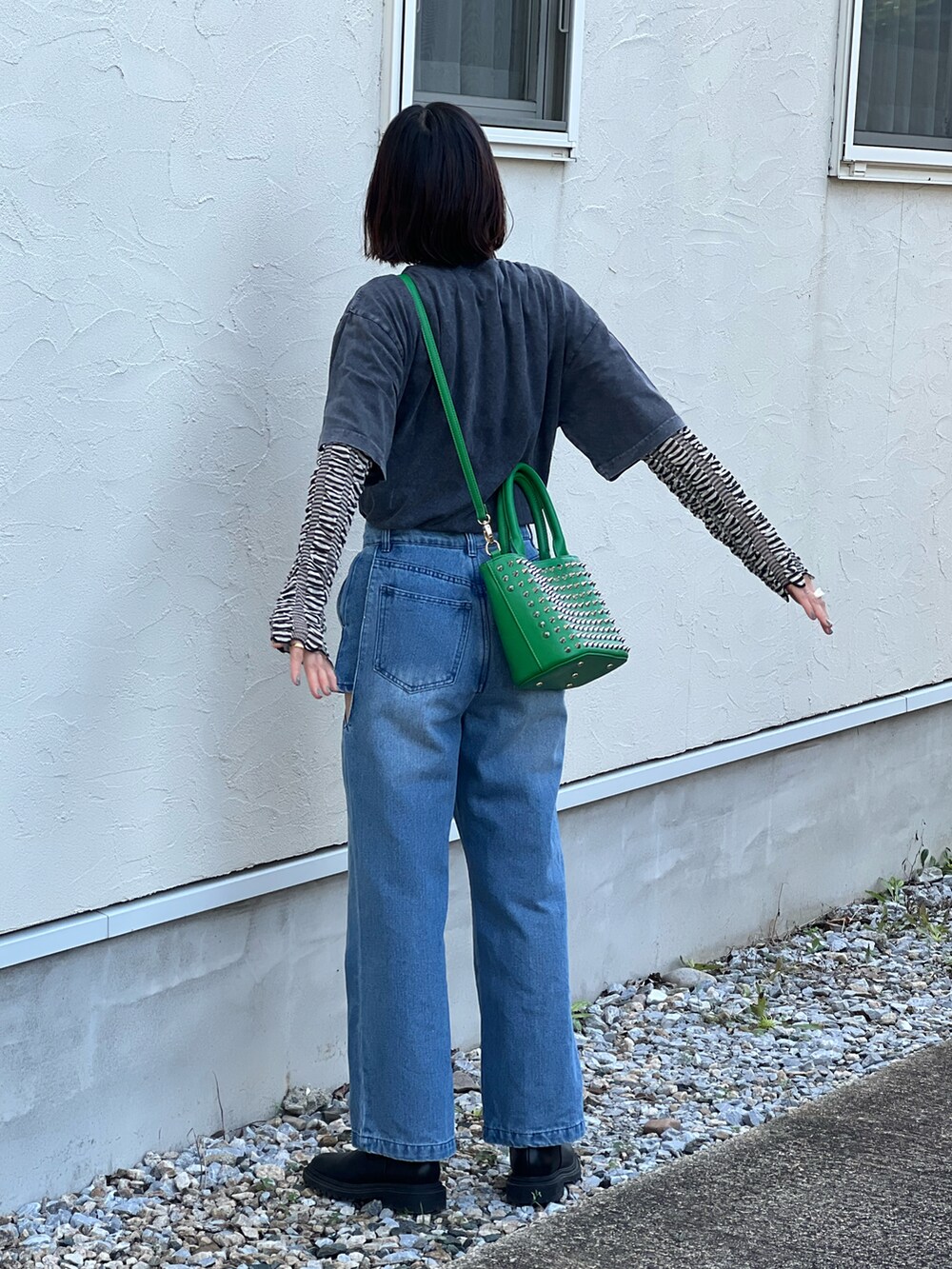 ブラック系のTシャツ/カットソー、ブラック系のニット/セーター、ブルー系のデニムパンツを着用したレディースの冬コーディネートの3枚目の写真