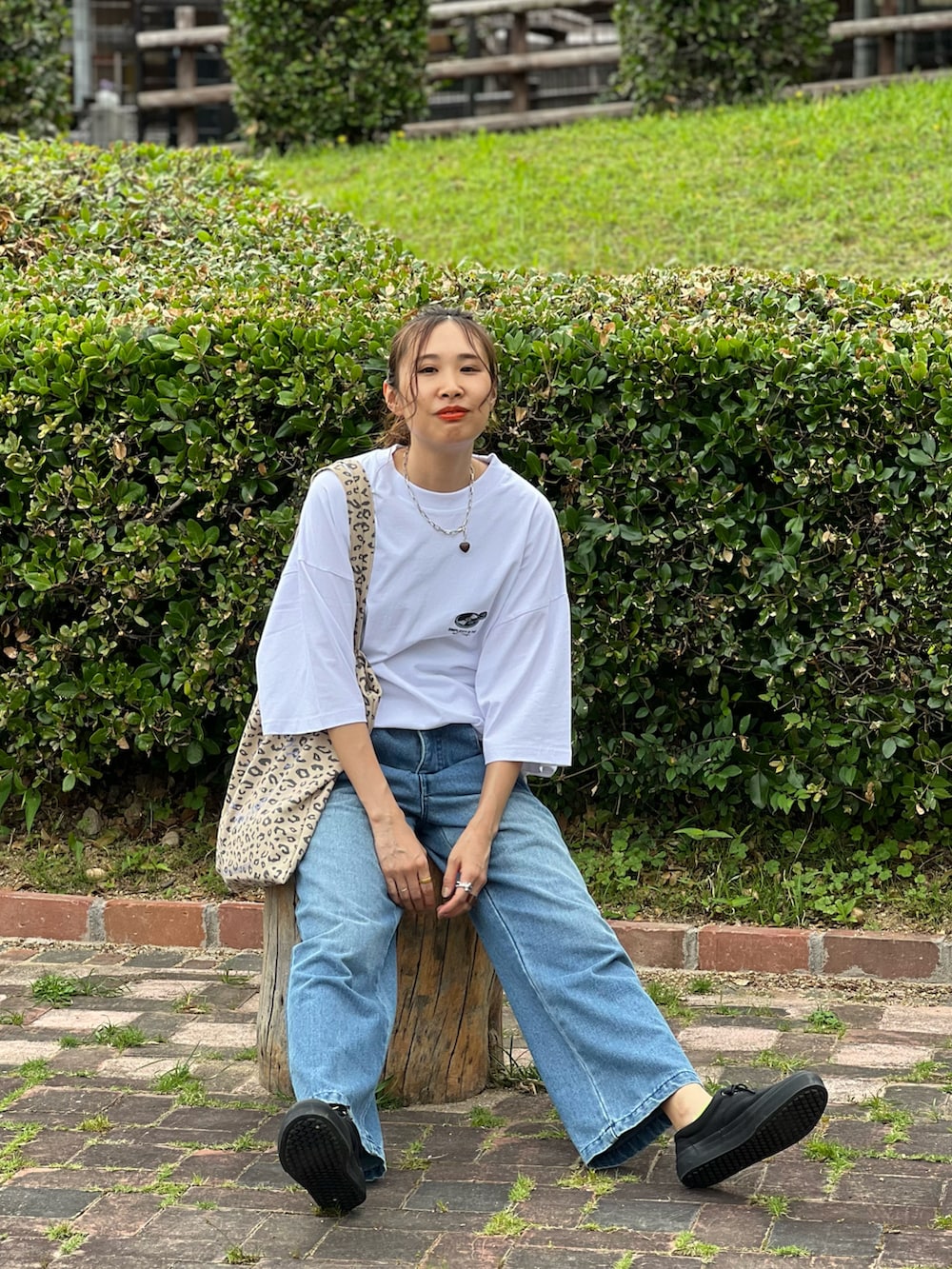 ホワイト系のTシャツ/カットソー、ブルー系のデニムパンツ、ブラック系のスニーカーを着用したレディースの夏コーディネートの5枚目の写真