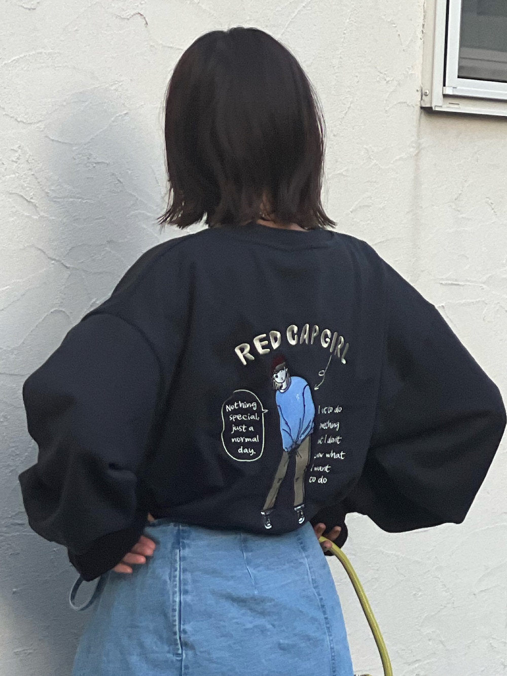 グレー系のスウェット、ブルー系のデニムパンツ、ブラック系のシューズを着用したレディースの秋コーディネートの2枚目の写真