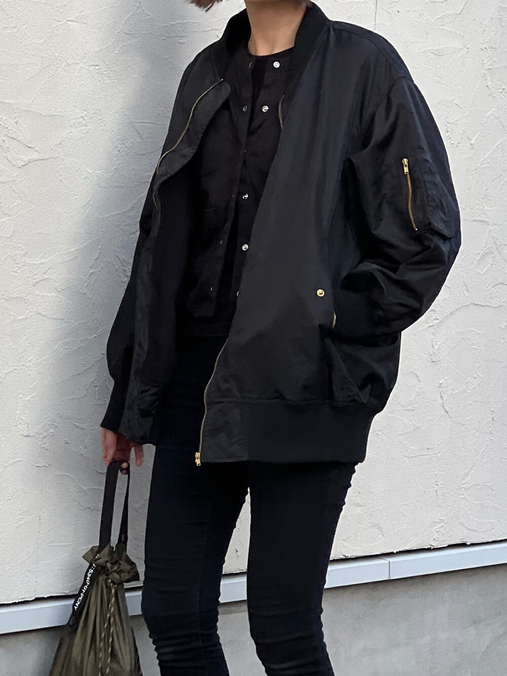 ブラック系のブルゾン、ブラック系のカーディガン/ボレロ、シルバー系のスニーカーを着用したレディースの冬コーディネートの3枚目の写真