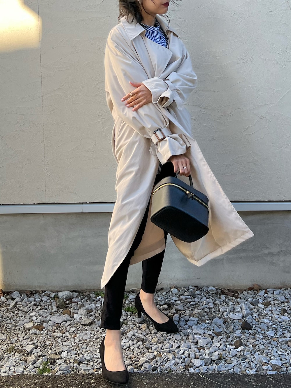 ベージュ系のトレンチコート、ブルー系のシャツ/ブラウス、ブラック系のその他パンツを着用したレディースの春コーディネートの5枚目の写真