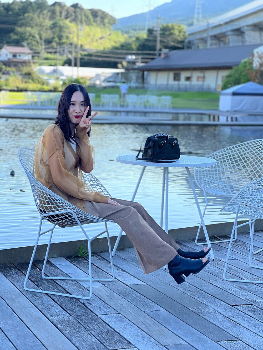 イエロー系のカーディガン/ボレロ、ベージュ系のその他パンツ、ブラック系のブーツを着用したレディースの夏コーディネートの2枚目の写真