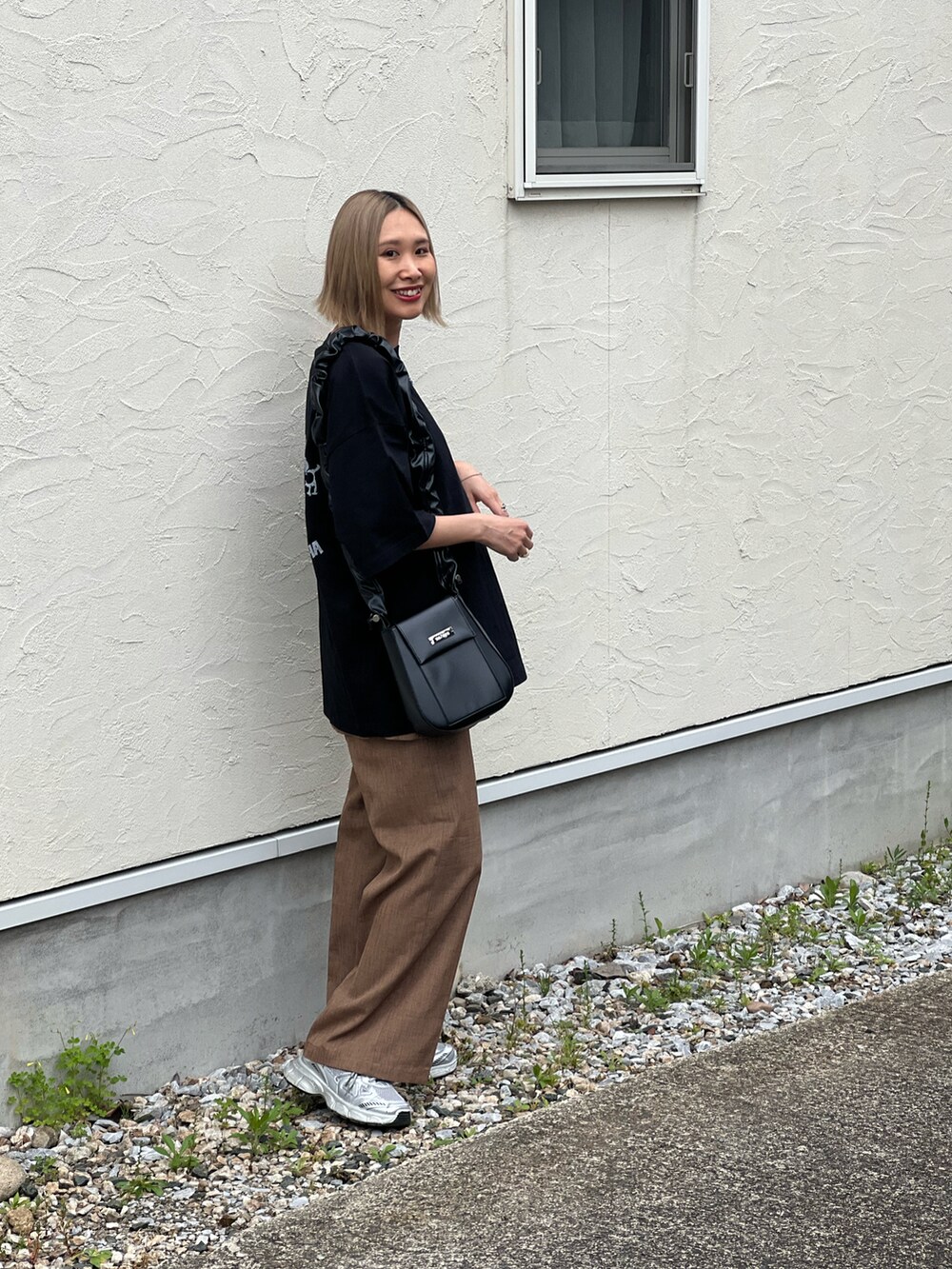 ブラック系のTシャツ/カットソー、ベージュ系のその他パンツ、シルバー系のスニーカーを着用したレディースの春コーディネートの5枚目の写真