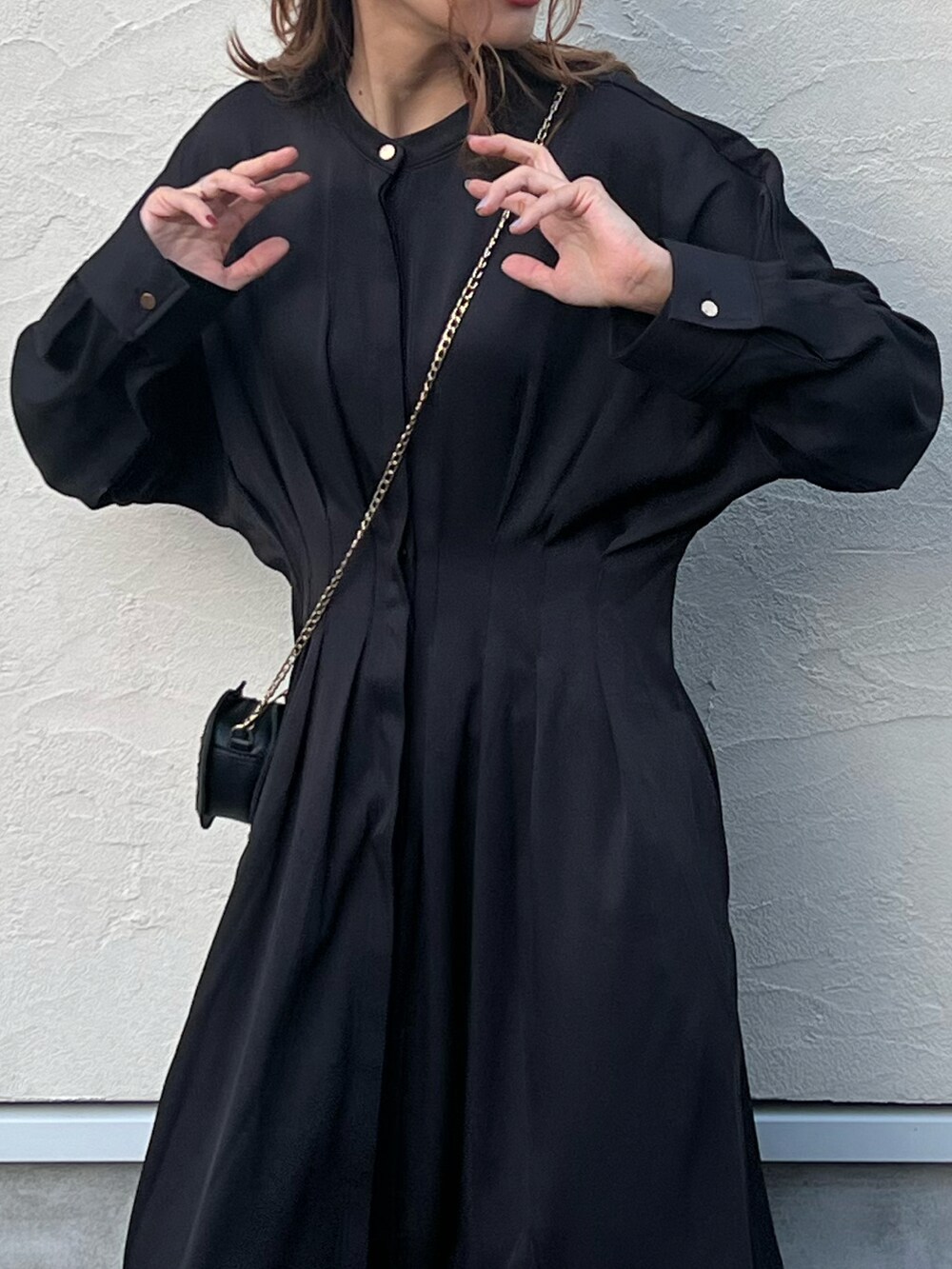 ブラック系のワンピース、ホワイト系のベスト、グレー系のスニーカーを着用したレディースの秋コーディネートの3枚目の写真