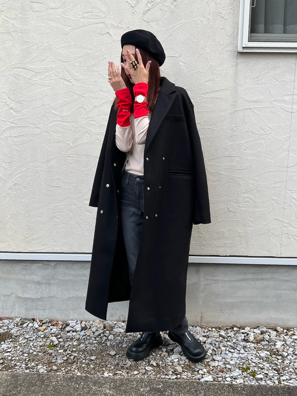 グレー系のデニムパンツ、レッド系のTシャツ/カットソー、ブラック系のチェスターコートを着用したレディースの冬コーディネートの4枚目の写真