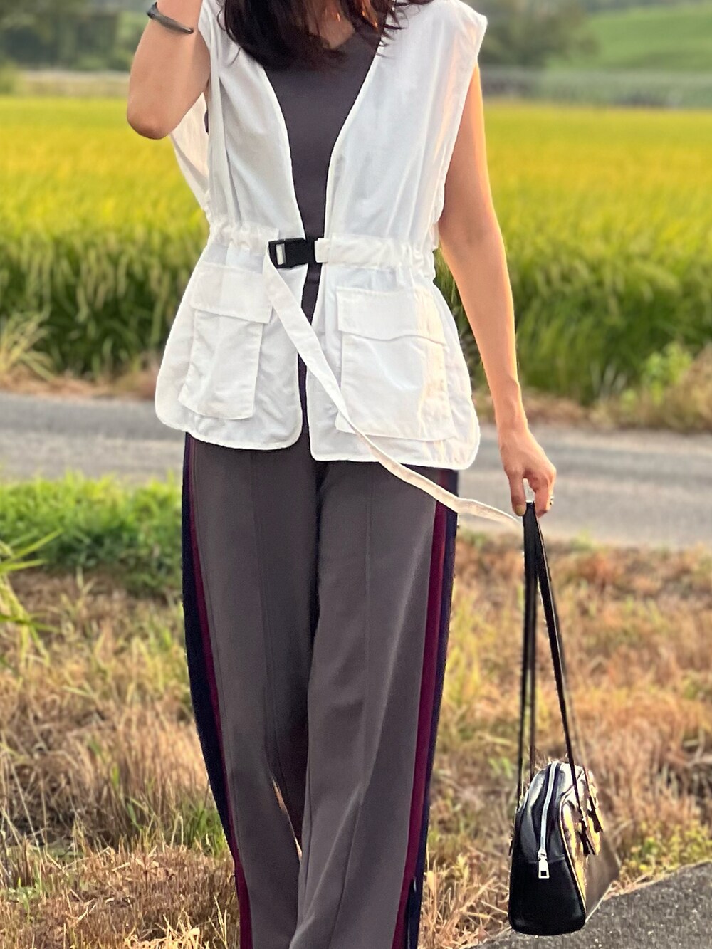 ホワイト系のベスト、グレー系のタンクトップ、グレー系のその他パンツを着用したレディースの夏コーディネートの3枚目の写真