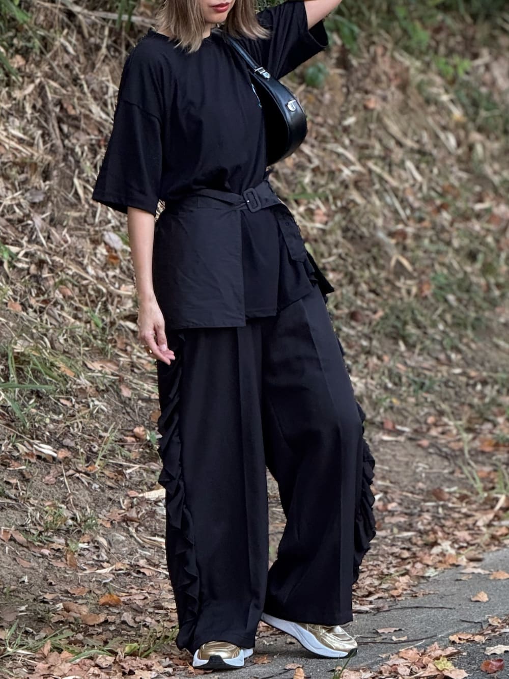 ブラック系のTシャツ/カットソー、ブラック系のその他パンツ、ゴールド系のスニーカーを着用したレディースの夏コーディネートの4枚目の写真