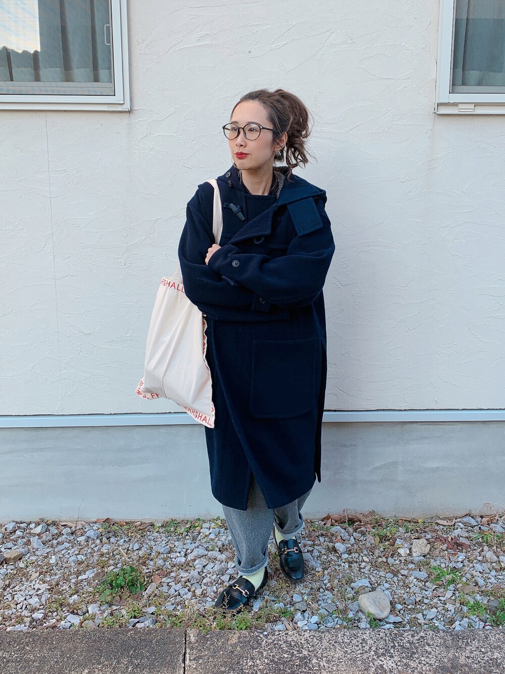 ブラック系のダッフルコート、ブラック系のローファー、レッド系のトートバッグを着用したレディースの冬コーディネートの3枚目の写真