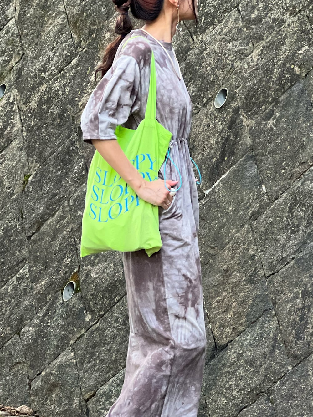 ブラウン系のワンピース、グレー系のスニーカー、グリーン系のトートバッグを着用したレディースの秋コーディネートの3枚目の写真