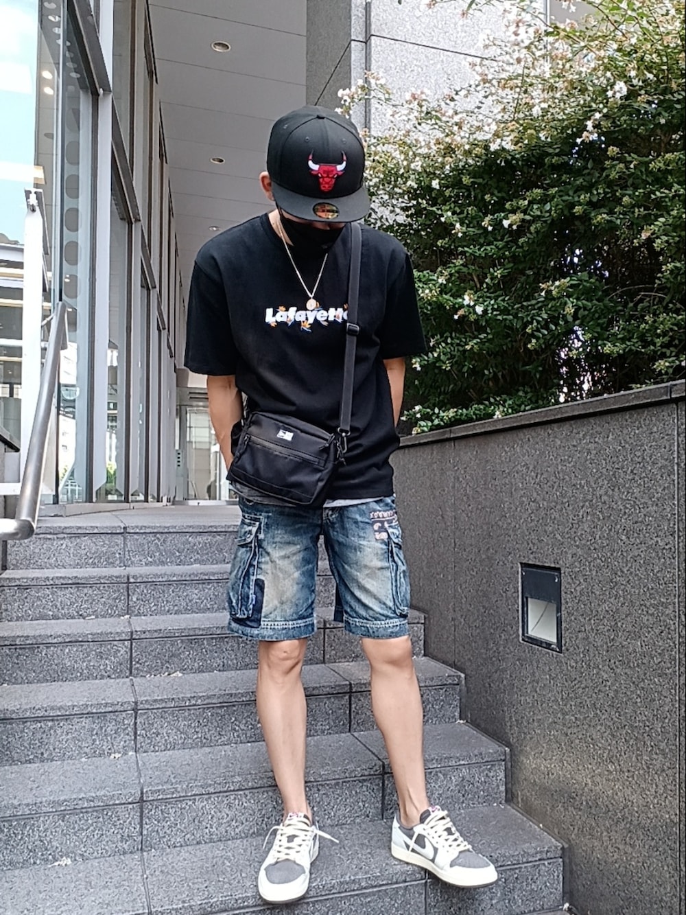 ブラウン系のスニーカー、ブルー系のデニムパンツ、ブラック系のTシャツ/カットソーを着用したメンズの秋コーディネートの3枚目の写真