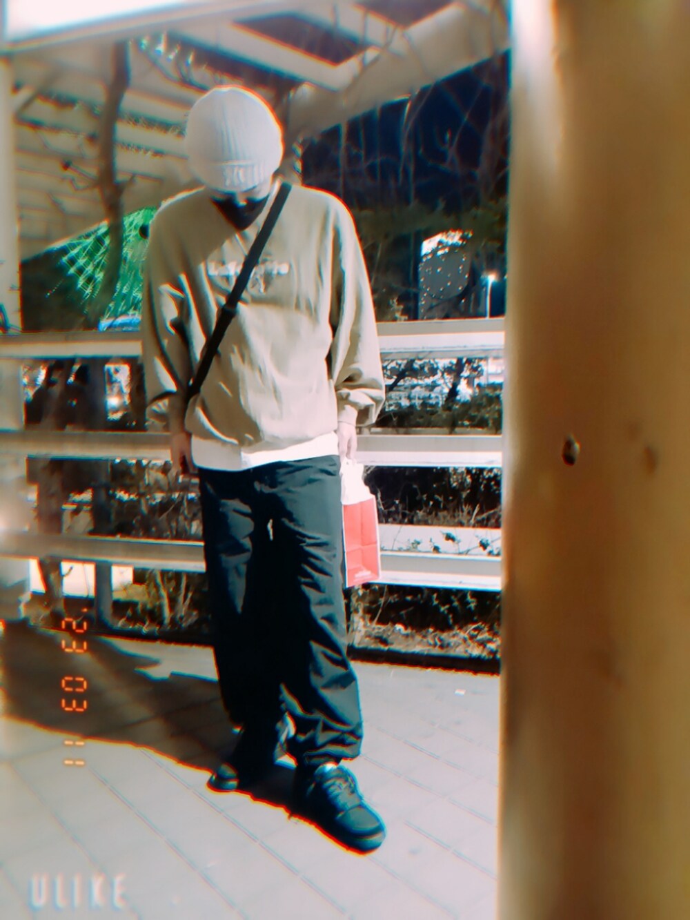 ベージュ系のスウェット、ブラック系のカーゴパンツ、ブラック系のスニーカーを着用したメンズの春コーディネートの3枚目の写真