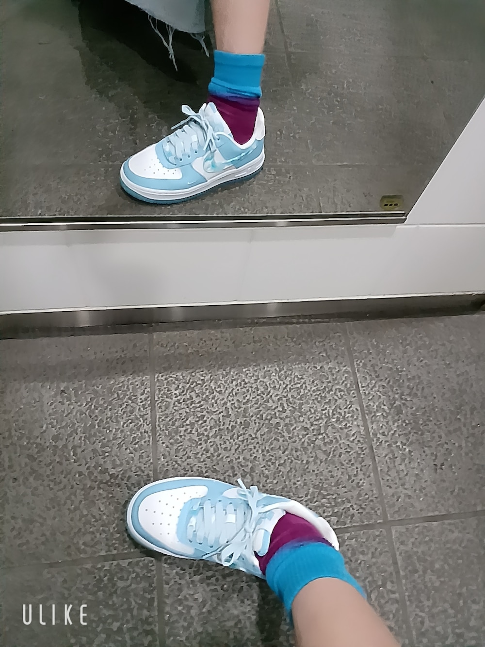 ブルー系のスニーカー、ブルー系のスカート、ブラック系のタンクトップを着用したレディースの秋コーディネートの3枚目の写真