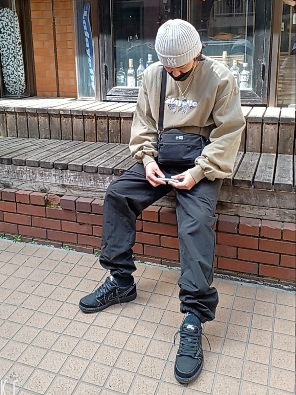 ベージュ系のスウェット、ブラック系のカーゴパンツ、ブラック系のスニーカーを着用したメンズの春コーディネートの4枚目の写真