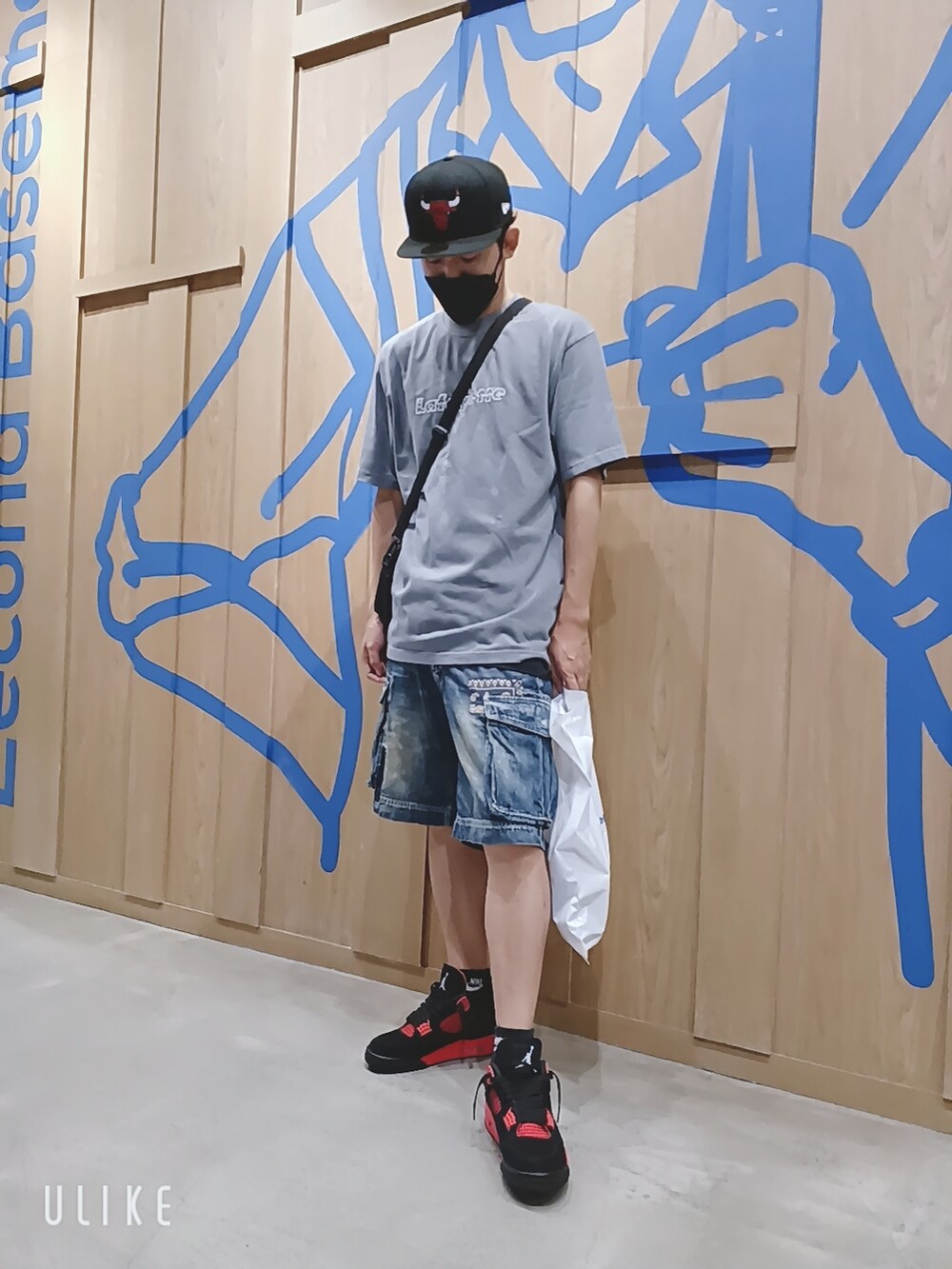 レッド系のスニーカー、グレー系のTシャツ/カットソー、ブラック系のキャップを着用したメンズの秋コーディネートの2枚目の写真