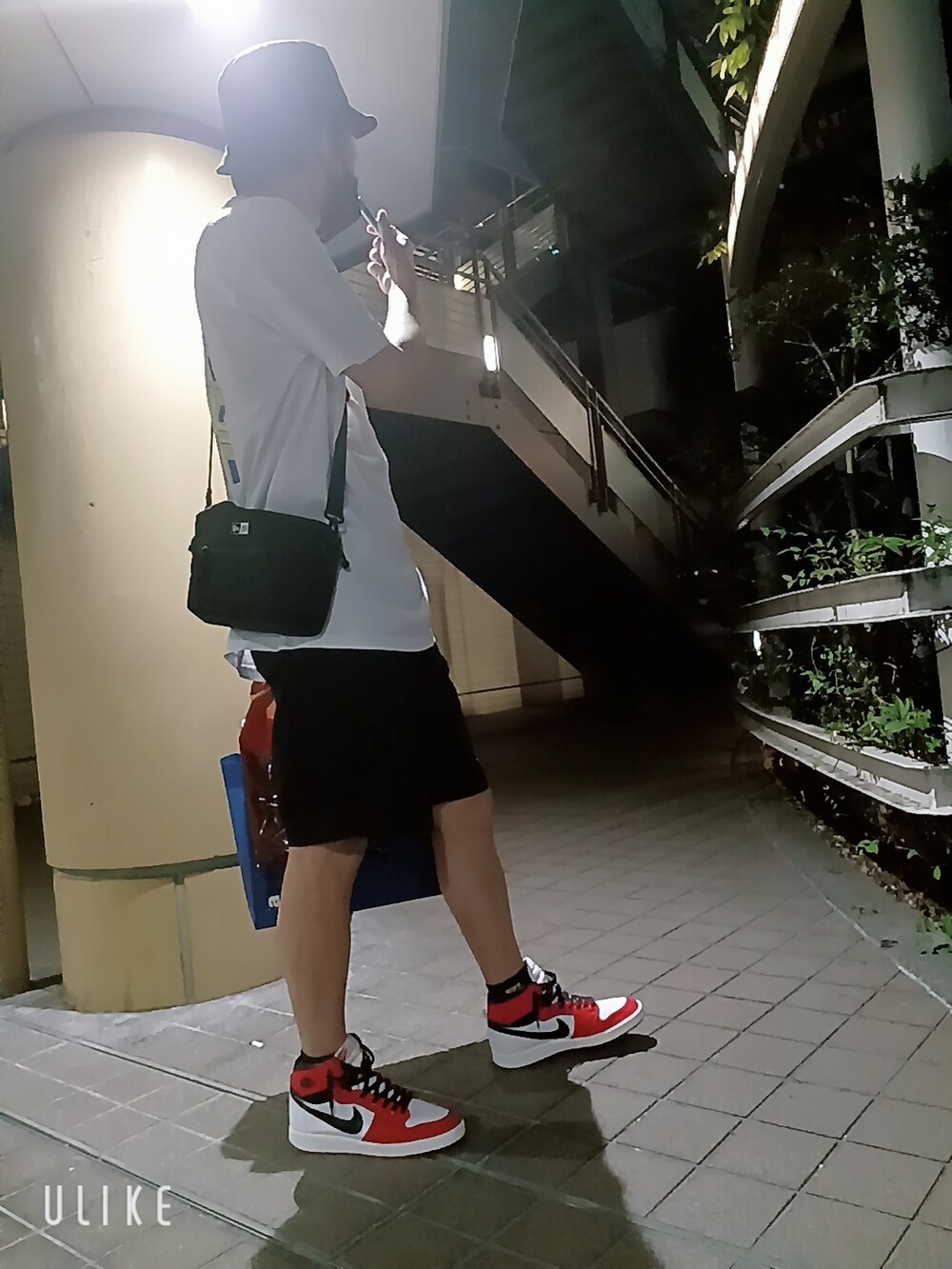 レッド系のスニーカー、ブラック系のその他パンツ、ホワイト系のTシャツ/カットソーを着用したメンズの夏コーディネートの3枚目の写真