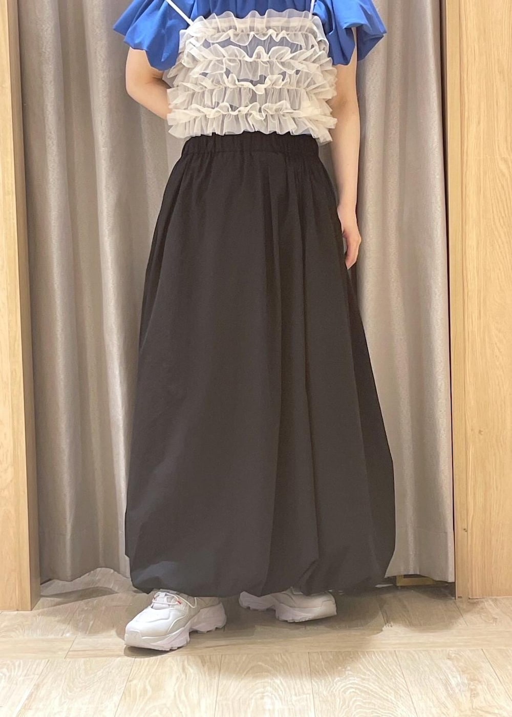 ホワイト系のハンドバッグ、ブルー系のTシャツ/カットソー、ブラック系のスカートを着用したレディースの春コーディネートの4枚目の写真