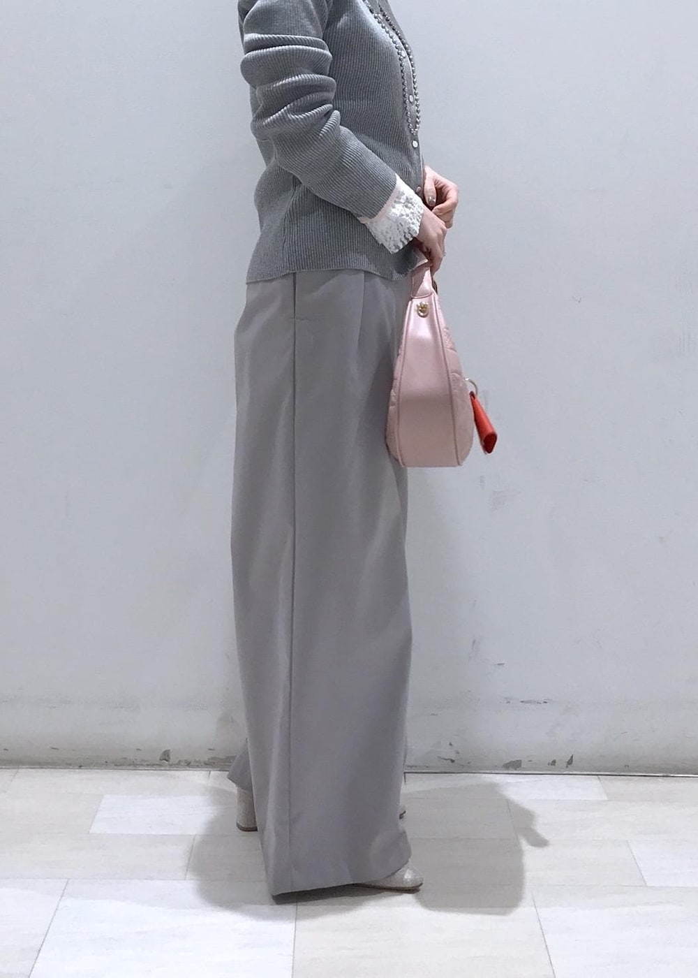 ピンク系のハンドバッグ、ベージュ系のパンプス、グレー系のカーディガン/ボレロを着用したレディースの冬コーディネートの7枚目の写真