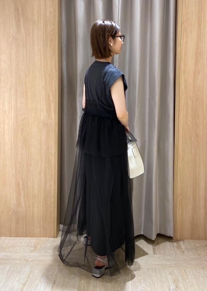 シルバー系のサンダル、ホワイト系のハンドバッグ、ブラック系のワンピースを着用したレディースの夏コーディネートの4枚目の写真