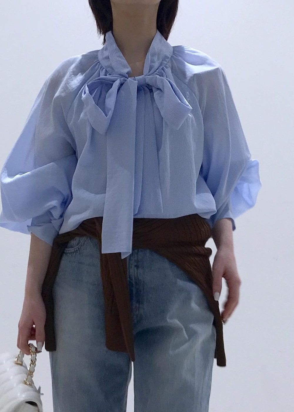 ブラック系のバレエシューズ、ブラウン系のカーディガン/ボレロ、ホワイト系のショルダーバッグを着用したレディースの冬コーディネートの5枚目の写真