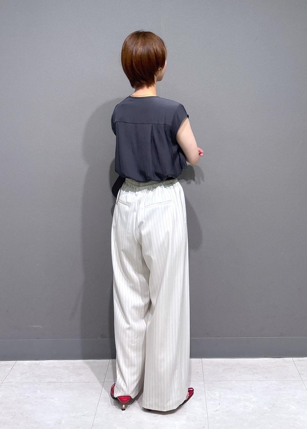レッド系のサンダル、ブラック系のショルダーバッグ、ホワイト系のその他パンツを着用したレディースの夏コーディネートの3枚目の写真