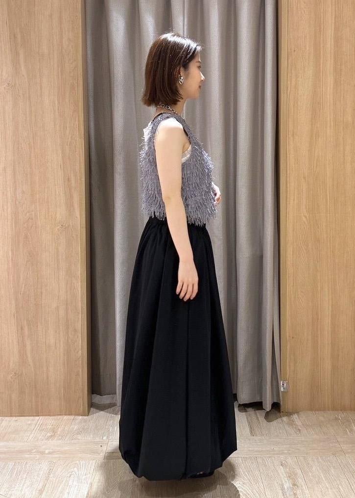 ブラック系のサンダル、ブラック系のスカート、グレー系のタンクトップを着用したレディースの夏コーディネートの2枚目の写真